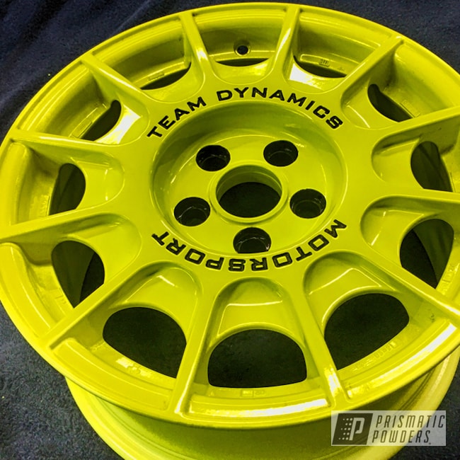 A Classic Rally Wheel By Team Dynamic Motorsport In A Neon Yellow With Black Letters And Lug Holes